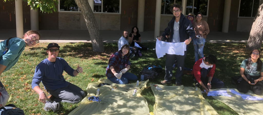 Graduate students create t-shirt designs outside on CSU campus